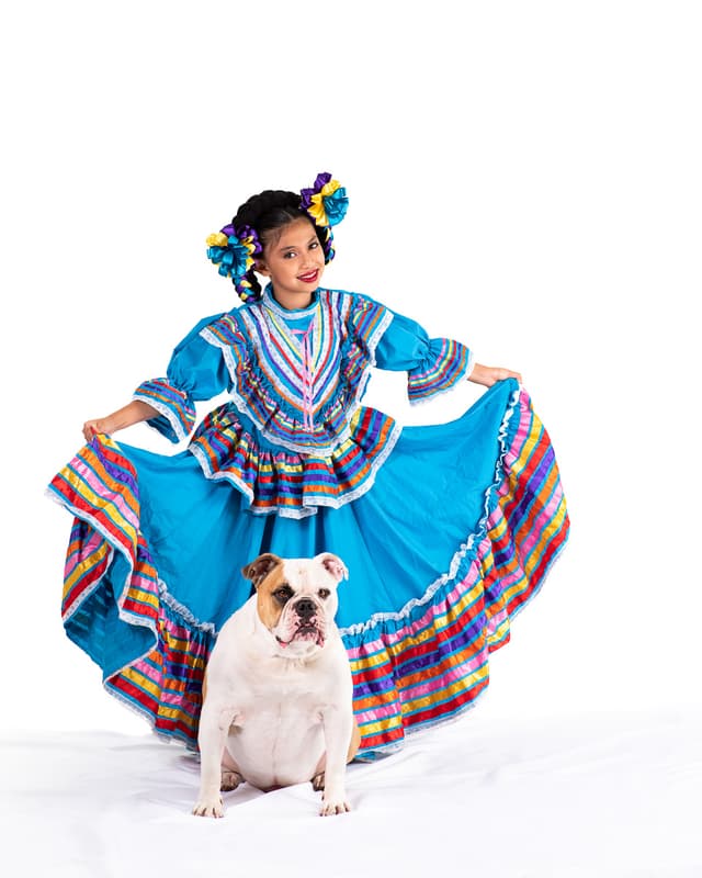 Girl in traditional Mexican costume with bulldog